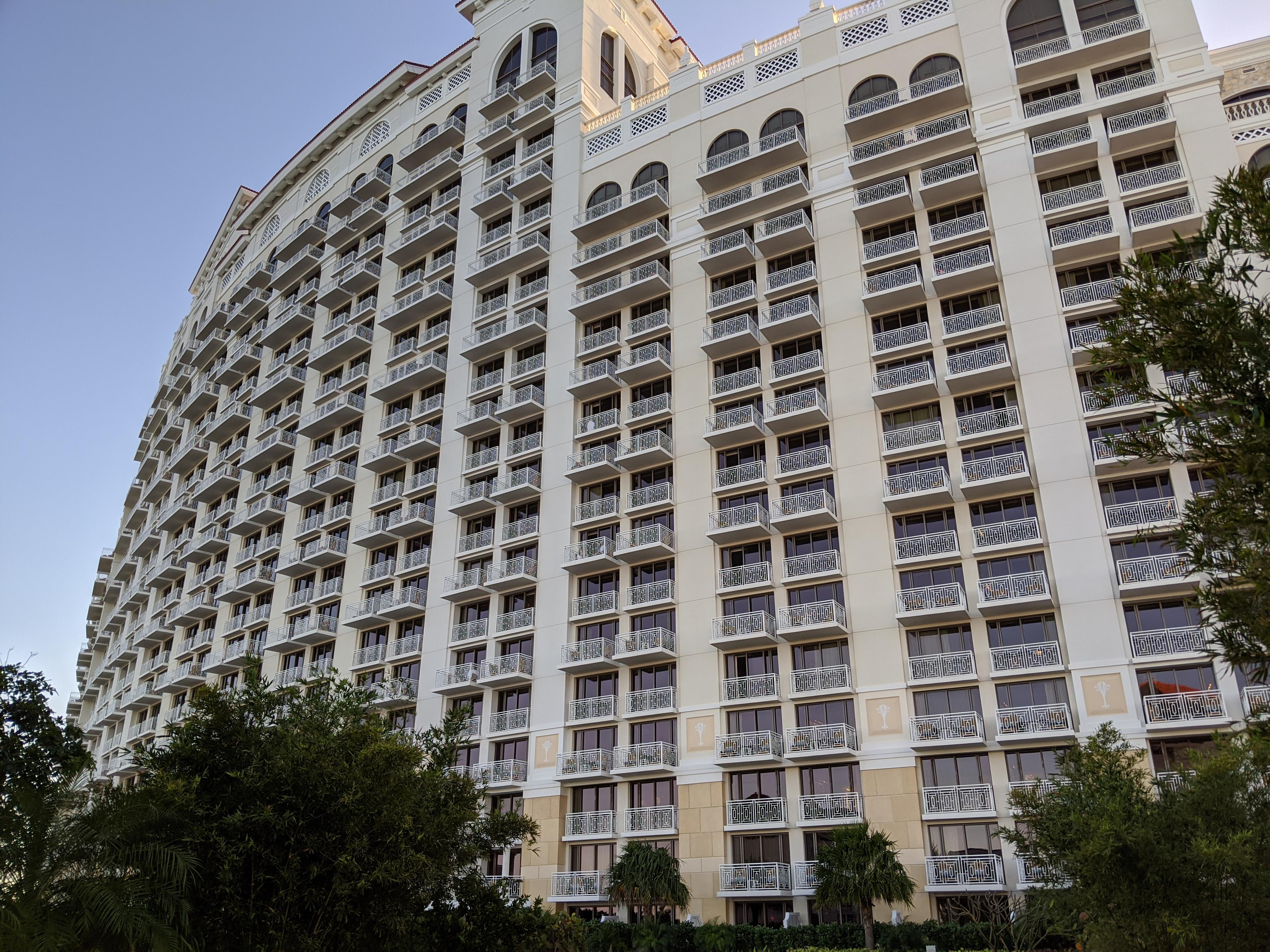 A curved white building with many balconies.