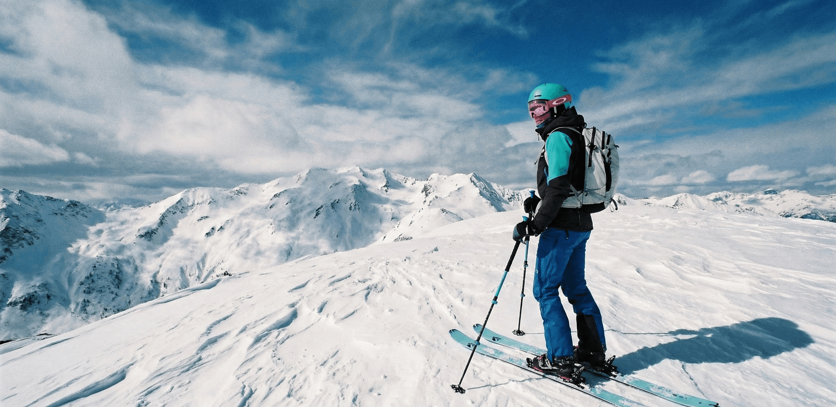 A skier stands in front of a snowy landscape