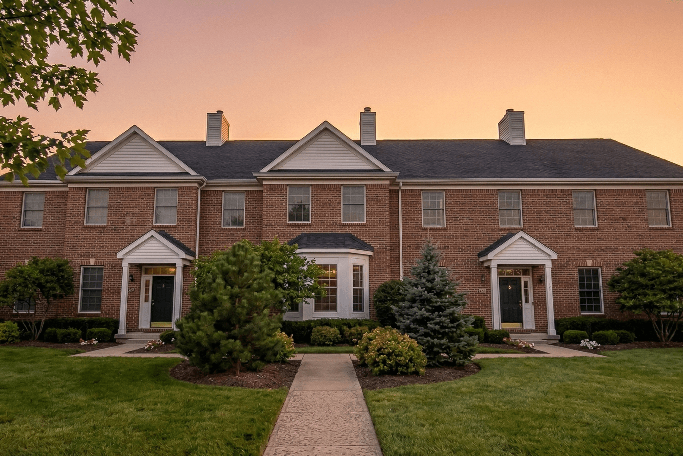 The front lawn and walkway of a townhouse building.